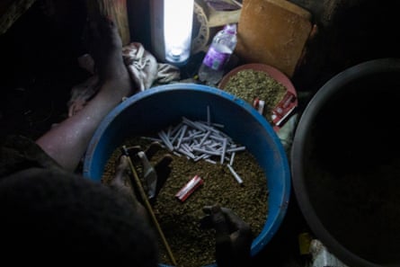 A child packages homemade marijuana inside a kiosk in Kisenyi.