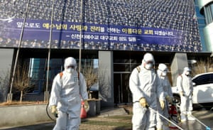 Workers from a disinfection service company sanitise the street outside the Shincheonji Church of Jesus in Daegu, South Korea, which is linked to 37 cases of Covid-19.