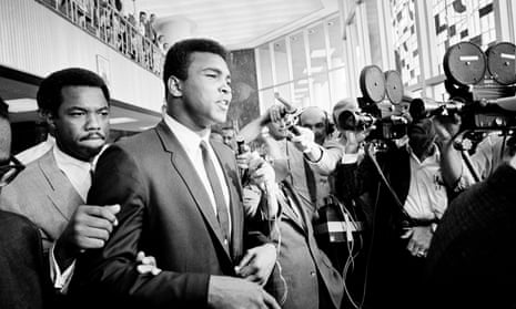 Muhammad Ali is confronted by journalists as he leaves the Federal Building in Houston for lunch during the noon recess, 19 June 1967. Ali faced trial for refusing to be drafted into the army.
