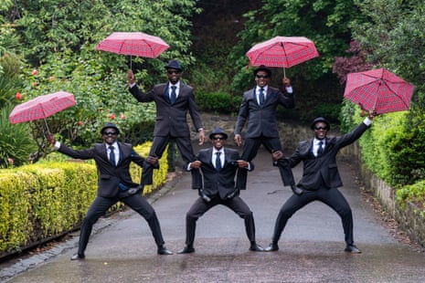 The Black Blues Brothers during a photocall for “Let’s Twist Again!” in front of the Scottish National Gallery in Edinburgh posing in an acrobatic tower with umbrellas