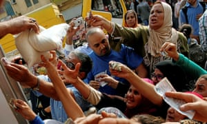 Egyptians compete to buy subsidised sugar from a government truck in Cairo