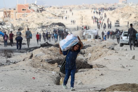 Os palestinos se reúnem ao longo da estrada costeira na área de Al-Sudaniyya, no norte de Gaza, enquanto esperam para receber a ajuda humanitária que deve entrar na travessia do zikim. Esta foto foi tirada em 24 de junho de 2025.