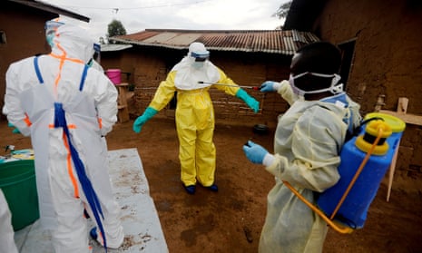 Healthcare workers are decontaminated after entering the house of an Ebola victim in the DRC