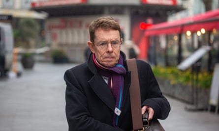 Andy Street walking along a street in a coat and scarf