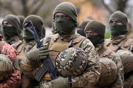 Members of the Armed Forces of Ukraine form up for a ceremony to mark one year since Russia invaded Ukraine at a training base near Salisbury, Britain.