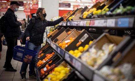 Customers shop for fruit and vegetables in a supermarket