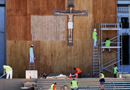 Workers prepare the decorations on the altar where the grand papal mass will take place in Plaza de Cibeles, Madrid.