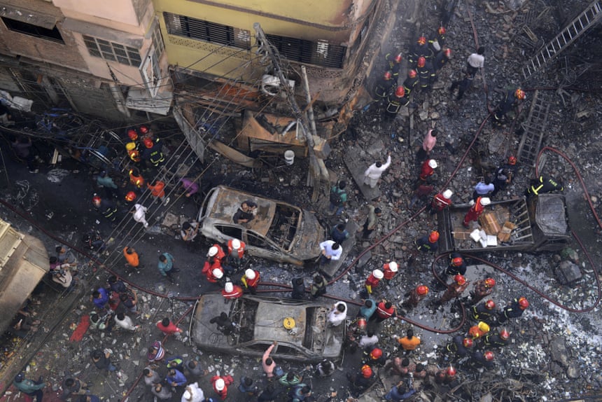 Rescuers stand at the site of the fire in Dhaka on Thursday morning.