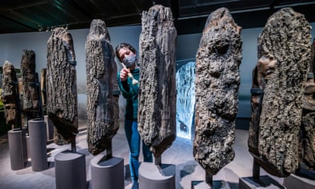 A curator working on the timber columns of Seahenge in The World of Stonehenge exhibition