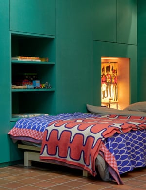 Green light: a teal wall cupboard next to a bed fitted into a snug alcove.