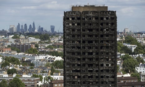 The City of London skyline is seen behind the burnt-out Grenfell Tower.