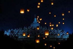 Buddhist devotees release lanterns into the air as part of the day’s rituals