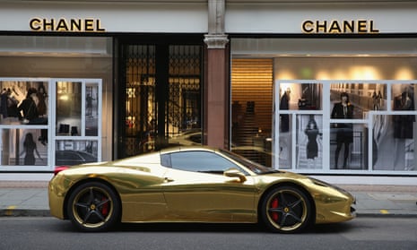 a gold luxury sports car outside a Chanel store