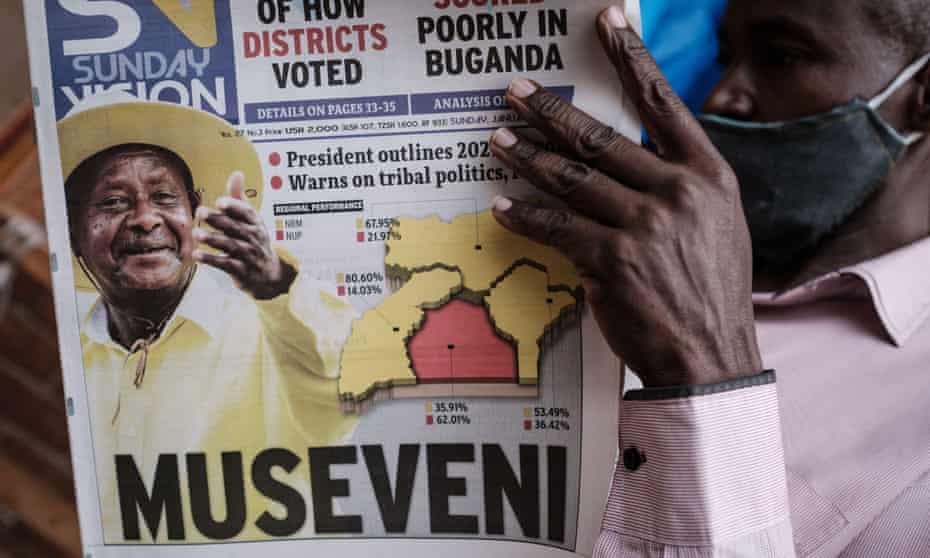 A man reads the Sunday Vision newspaper which shows a portrait of Yoweri Museveni