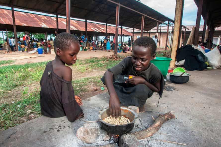 Two children cook maize at a camp for displaced people in Malawi.
