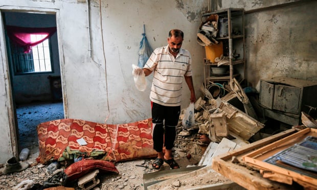 A relative of 23-year-old Palestinian Enas Khammash, who was killed along with her daughter in an Israeli airstrike, inspects their damaged home