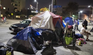 A police car stops beside tents on Skid Row in Los Angeles.