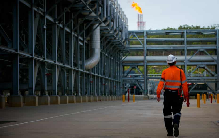 A worker walks through the Queensland Curtis Liquefied Natural Gas project site