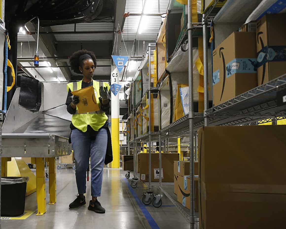 An Amazon worker sorts packages in a warehouse in Goodyear, Arizona.