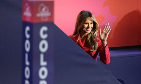woman in red jacket waves