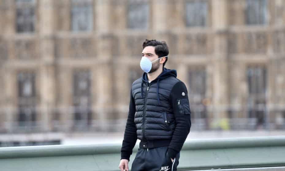 A pedestrian wears a protective face mask in central London
