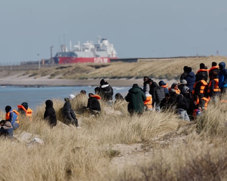 A group of people on a sand dune.