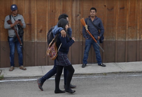 Students pass FUPCEG vigilantes outside the group’s base in Filo de Caballos.