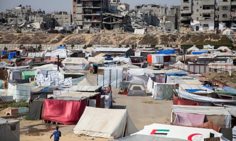 Palestinians shelter in a tent camp as houses destroyed in Israeli strikes lie in ruins in Khan Younis.