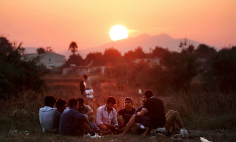 Migrants from Pakistan rest in a field on the Greek island of Kos