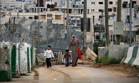 Una donna palestinese e i suoi figli attraversano un posto di blocco militare israeliano in Cisgiordania nel 2008.