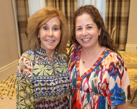 Two women wearing printed tops smiling