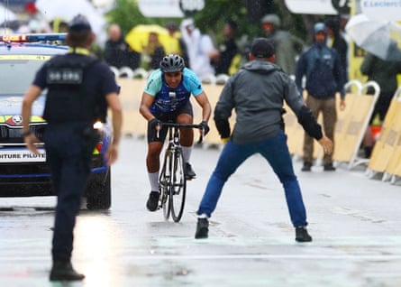 Security members stop a man cycling towards the finish line at the end of stage 17 of the Tour de France.