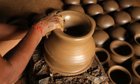 A potter's hands working on a clay vase in India