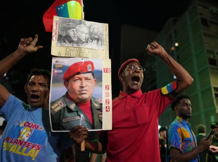 Maduro supporters in Caracas hold up a sign featuring a picture of Hugo Chávez.