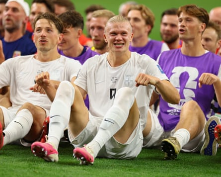 Erling Haaland and teammates sit on the turf doing the Viking row