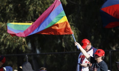 A Melbourne fan waves a pride flag after a goal during a AFLW match
