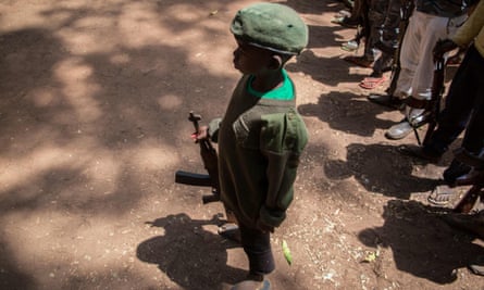 A newly released child soldier stands with his rifle during a release ceremony in Yambio