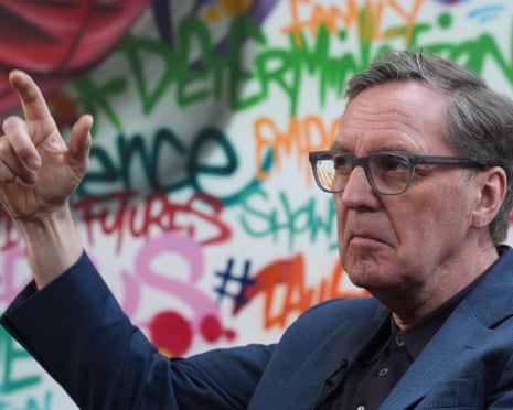 Alan Milburn in front of a wall of graffiti