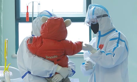 a small child with two people in PPE in a hospital room