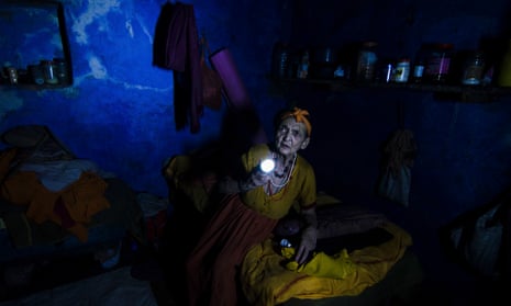 An elderly woman searches for her medicines during a power cut in the Indian city of Varanasi
