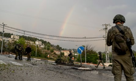 Soldiers stand on road strewn with debris