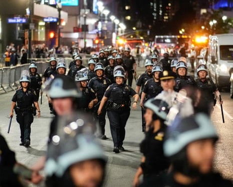 police in helmets walk on a street