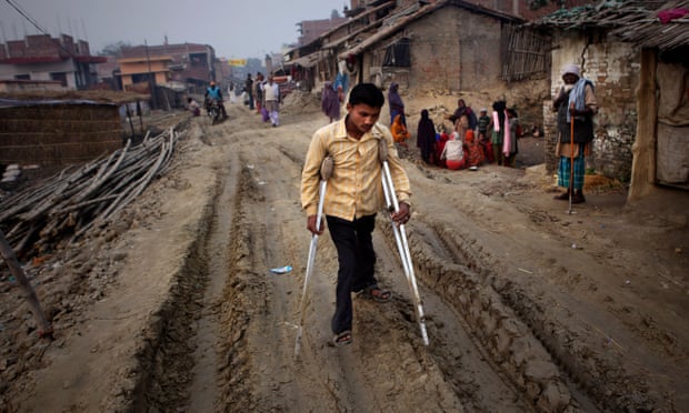A polio-affected man walks on crutches in the village of Kosi, India. Disruption caused by Covid has seen particularly sharp falls in vaccination rates in India.