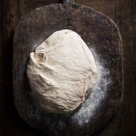 Bread dough resting on wooden board 