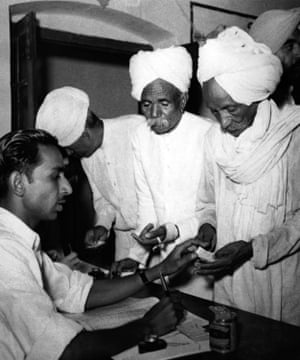 Voters receive ballots from polling station officials in Delhi on 14 December 1951