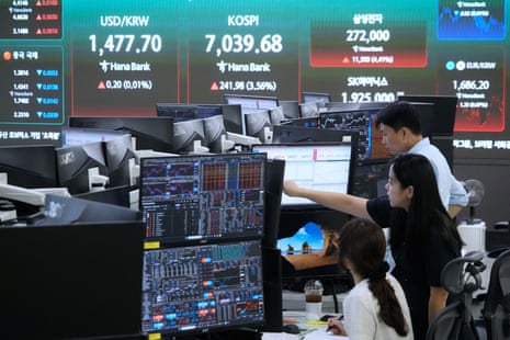 Currency traders work near a screen showing the Korea Composite Stock Price Index (Kospi) in Seoul.