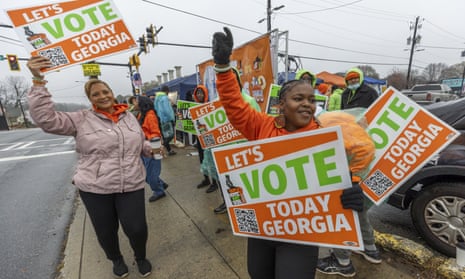people hold signs that say 'lets vote today georgia'