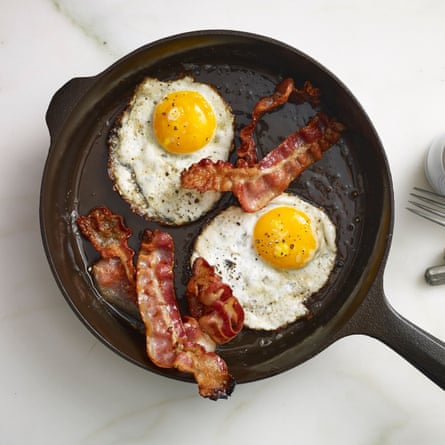 fried eggs and bacon in cast iron pan on kitchen counter
