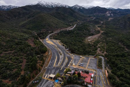 An aerial view of the El Teniente copper mine with snow-capped mountains in the background