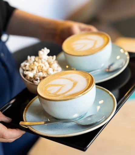 A waiter serving two cups of coffee